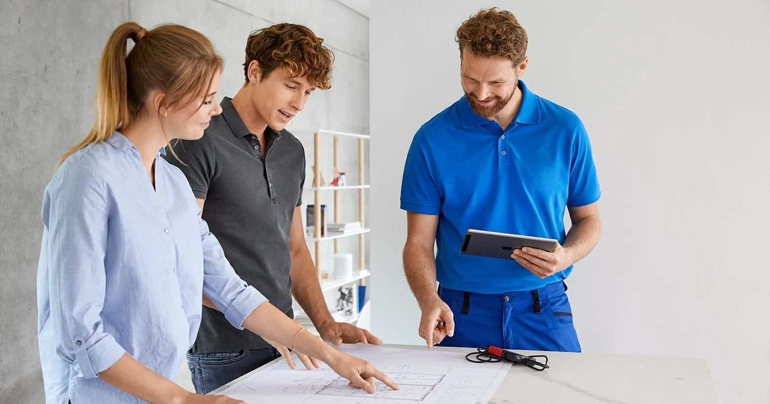 An electrician goes over drawings with the homeowners