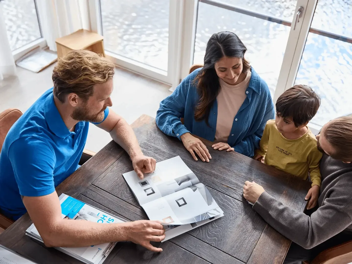 An electrician goes over a brochure with a family at the kitchen table