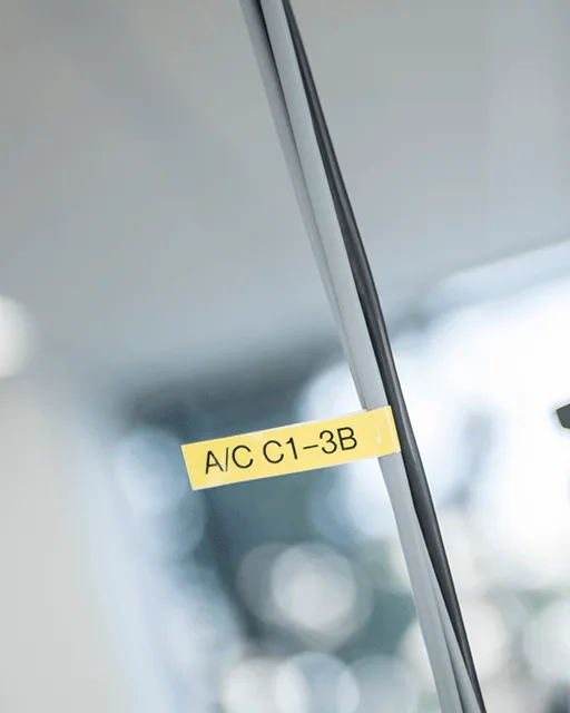 Yellow cable flag printed on a Brother label printer on a cable in a cable route