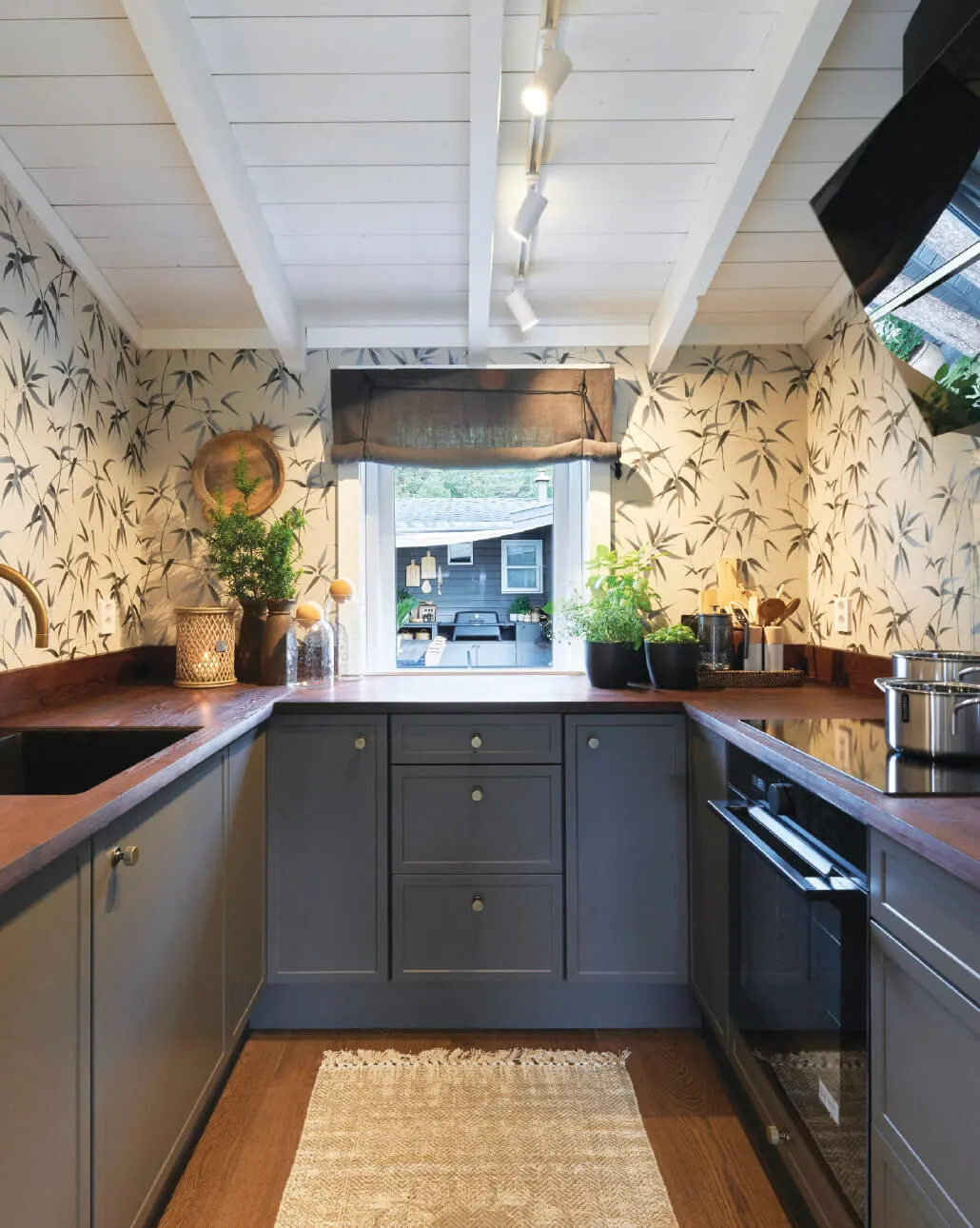 A kitchen with a straight row of track spots in a white timber ceiling
