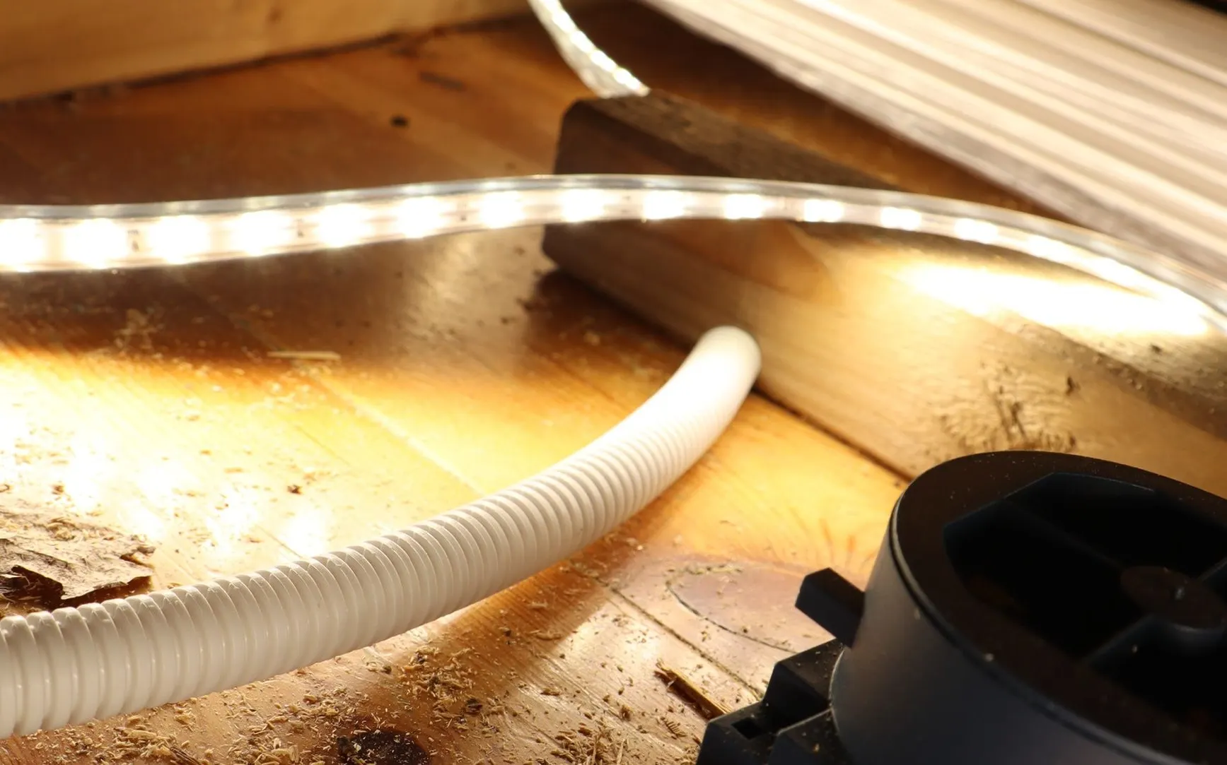 ETLED strip lights up a conduit and a box on the floor in a building under construction