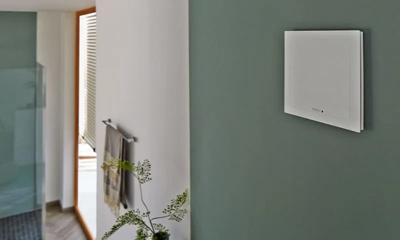 White Helios fan on a green wall by a bathroom door