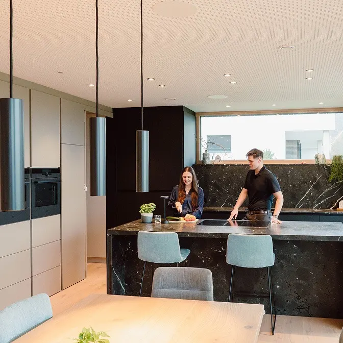 A couple cooking together in a kitchen with Loxone lighting