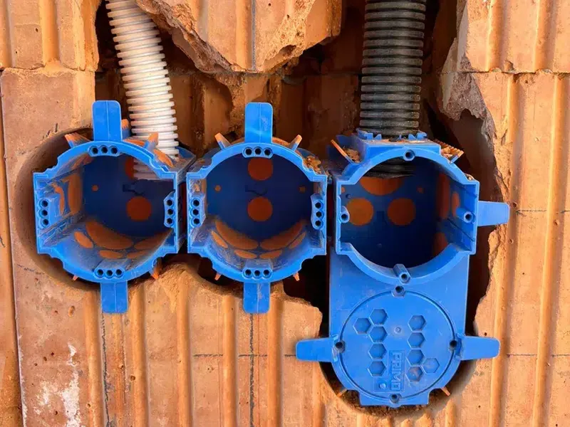 Three blue PRIMO Thermo boxes in a row in a brick wall, conduits fitted