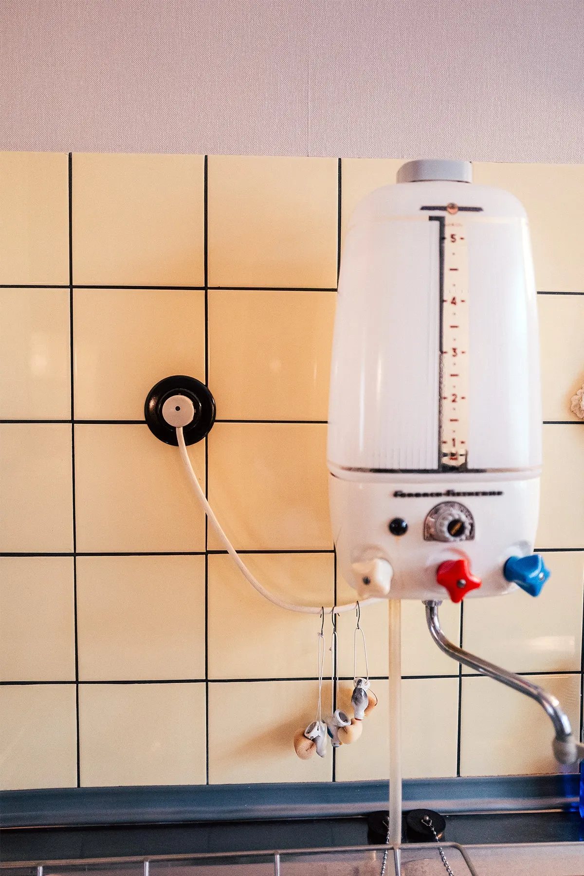 White tiles, an old water heater and a black Bakelite socket