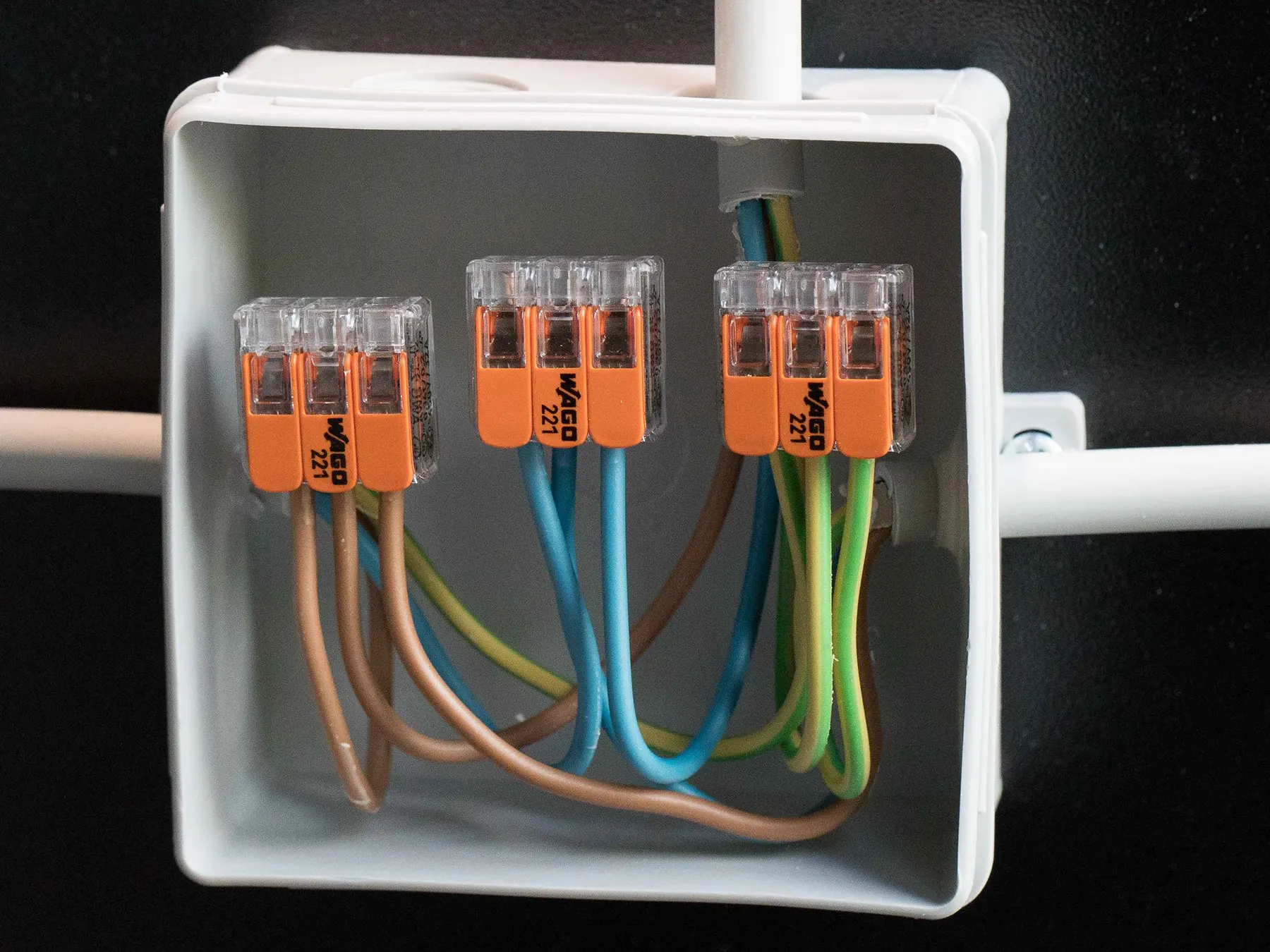 A neatly wired junction box with three WAGO 221 lever connectors