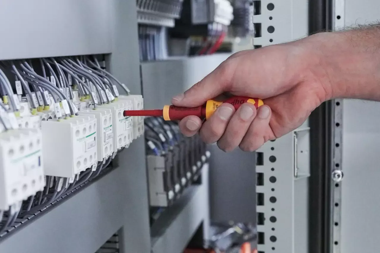 A Wiha SoftFinish electric stubby screwdriver in a terminal row in an electrical cabinet
